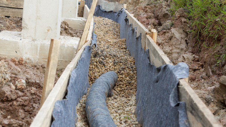 pipe disappearing into gravel bed