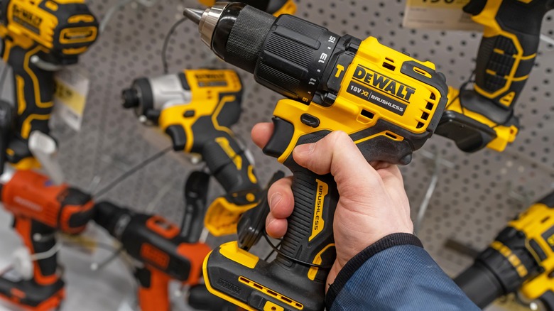 Person holding DeWalt cordless drill in a store