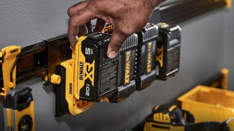 Hand replacing battery on DeWalt Battery Rail