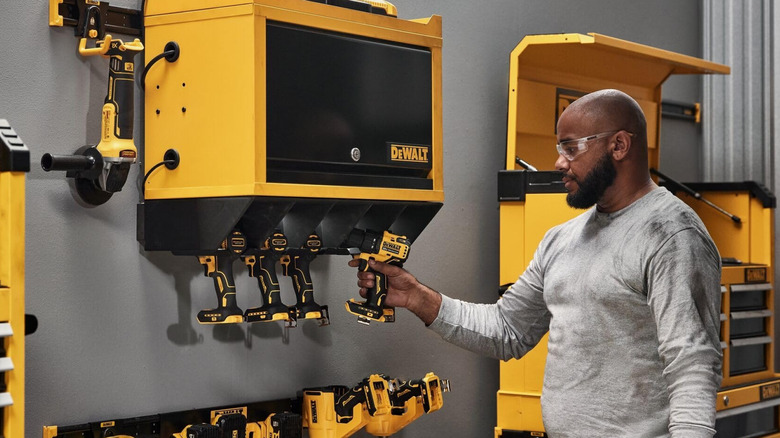 Man hanging power drill from DeWalt Power Tool Wall Cabinet