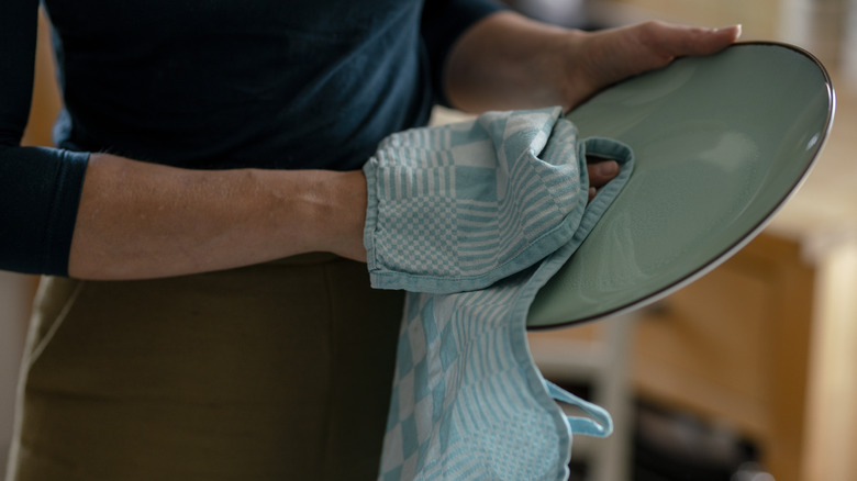 woman drying dish with towel