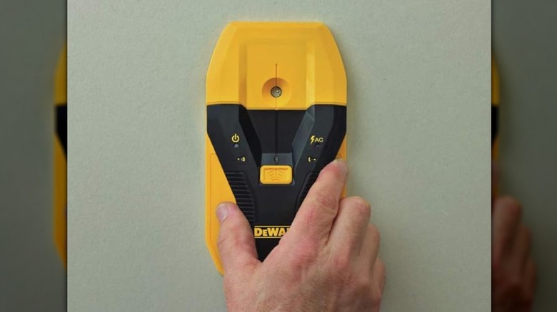 person using DeWalt stud finder