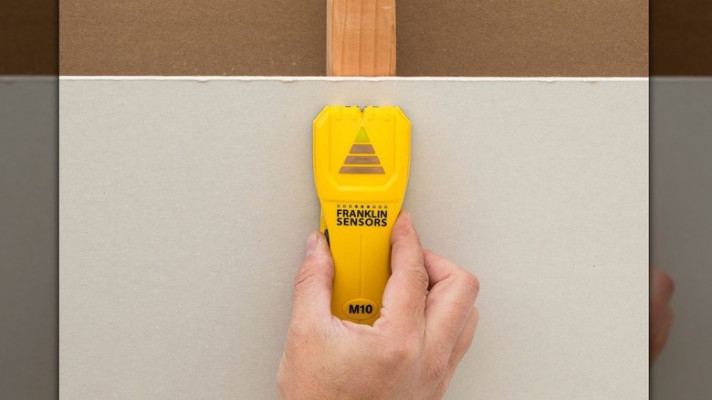 person using ProSensor stud finder