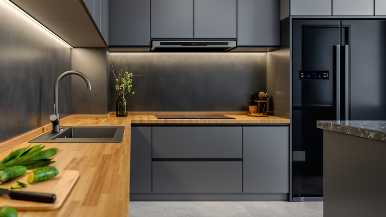 Black refrigerator in gray kitchen with wood counters