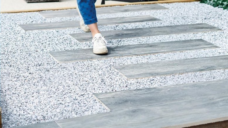 A person walking across gravel