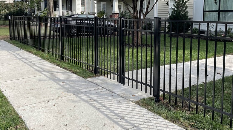 A black aluminum fence in front of a house