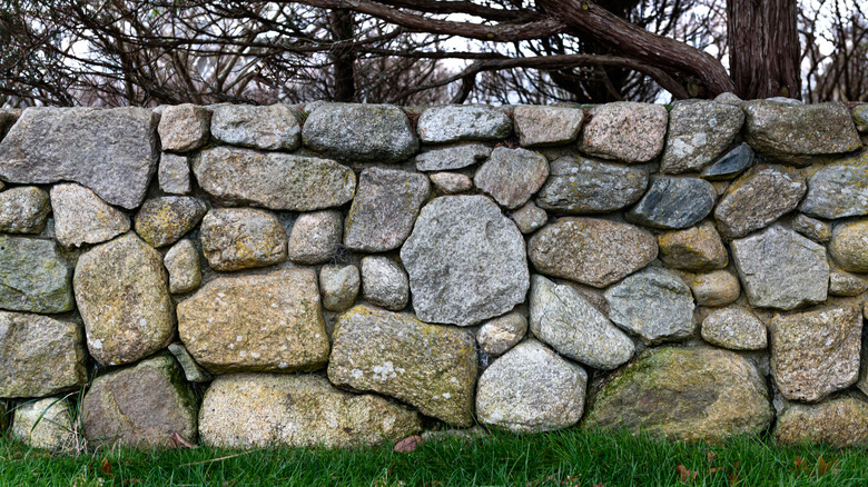 A natural stone fence on grass