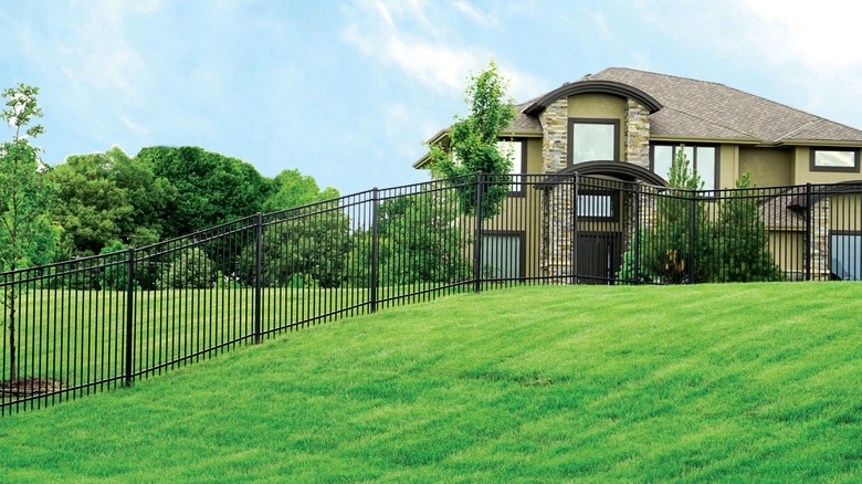 A steel fence outside a large house