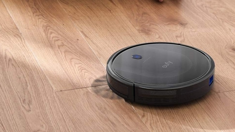 black robot vacuum on hardwood floor