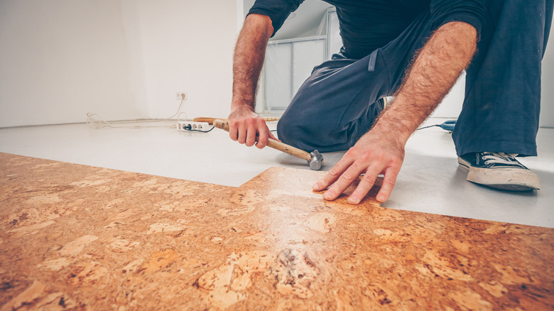 Person installs cork floors in home.