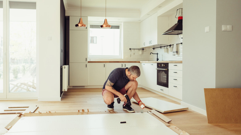 Man installs new floors in kitchen