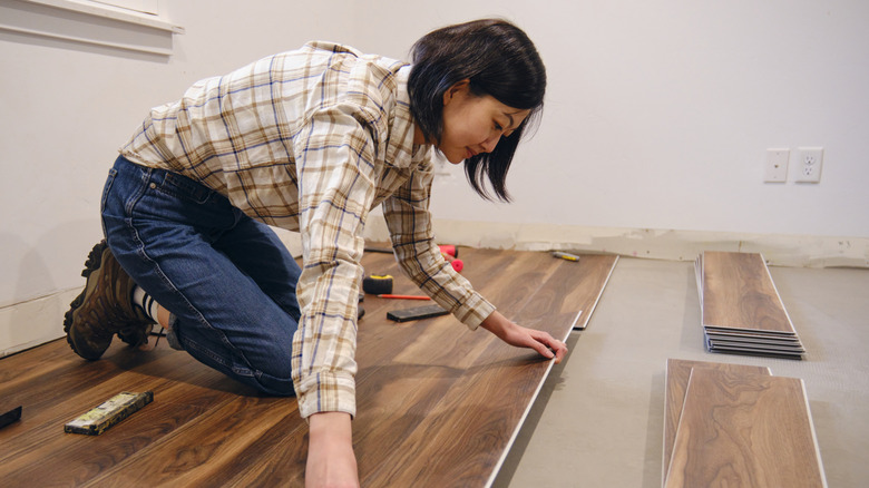 Woman installs laminate floors in home