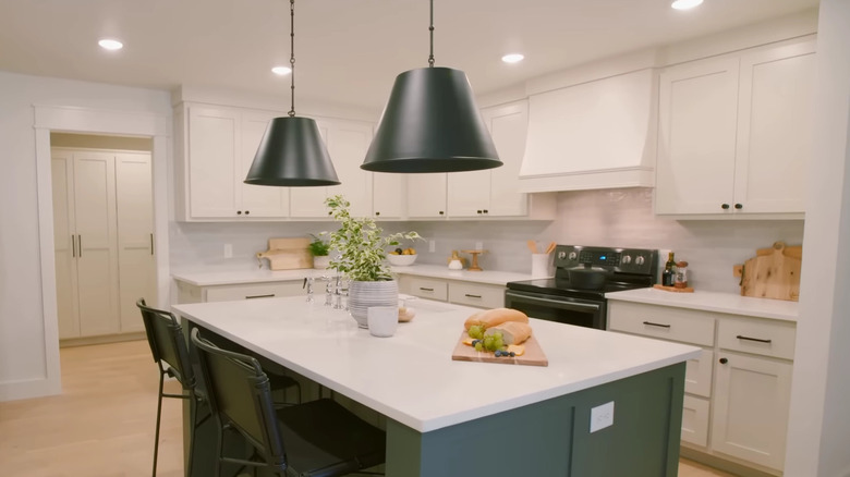 white kitchen with black chairs and lights