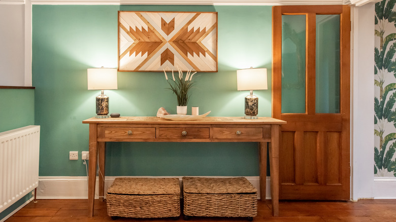 An entryway with a console table and artwork