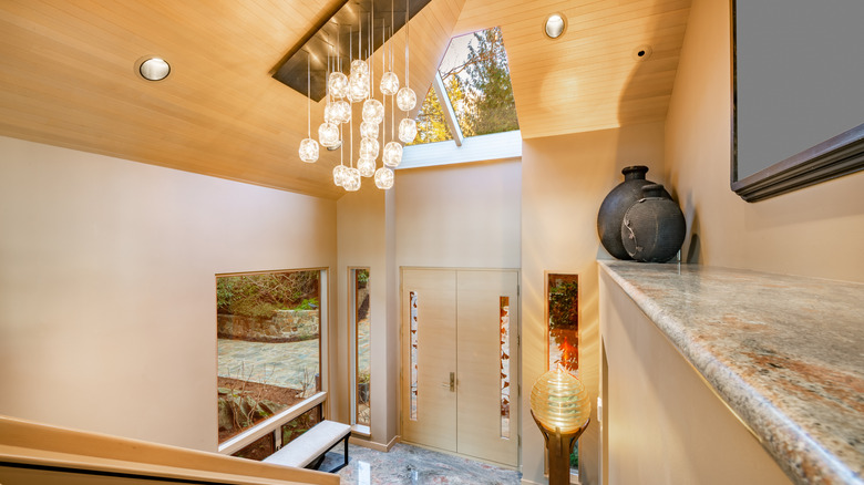 An entryway with a lamp and a hanging light fixture