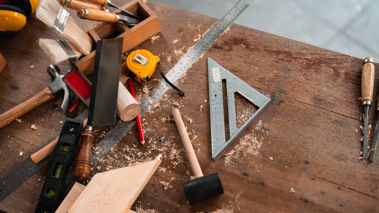 woodworking and handyman tools on wooden desk with wood shavings