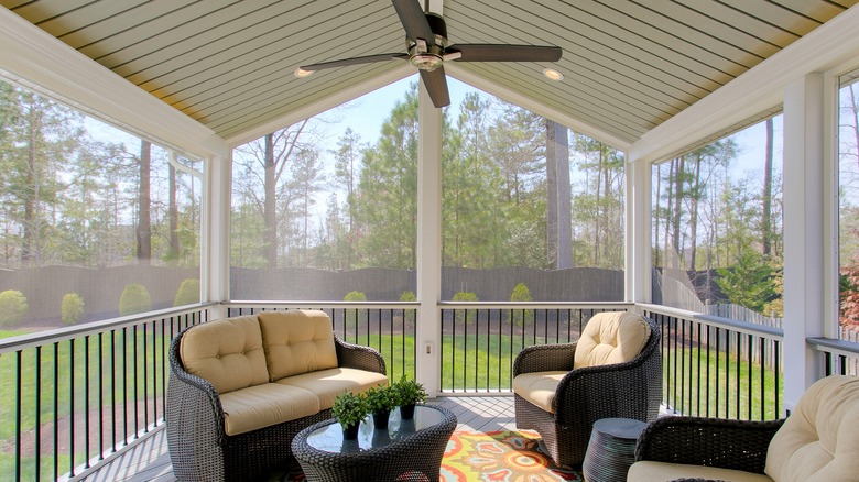 A sitting area in a screened-in porch.