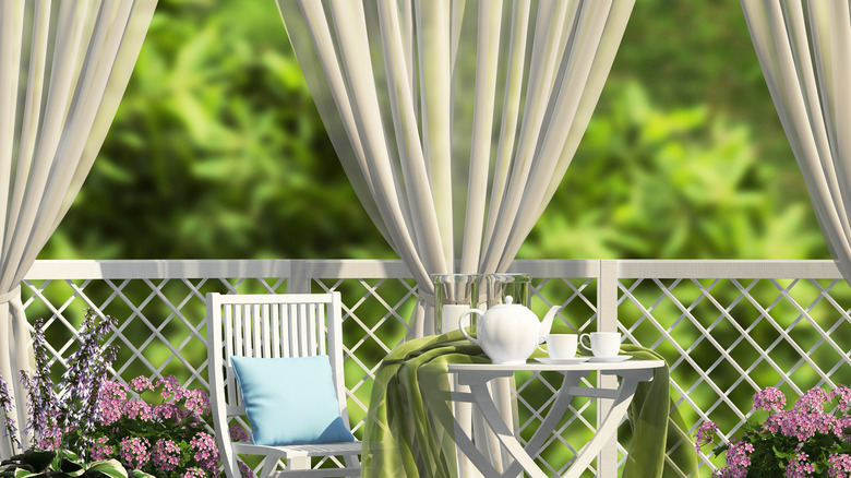 Outdoor curtains hanging next to a seating area.