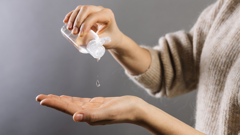 woman squirting rubbing alcohol on her hand