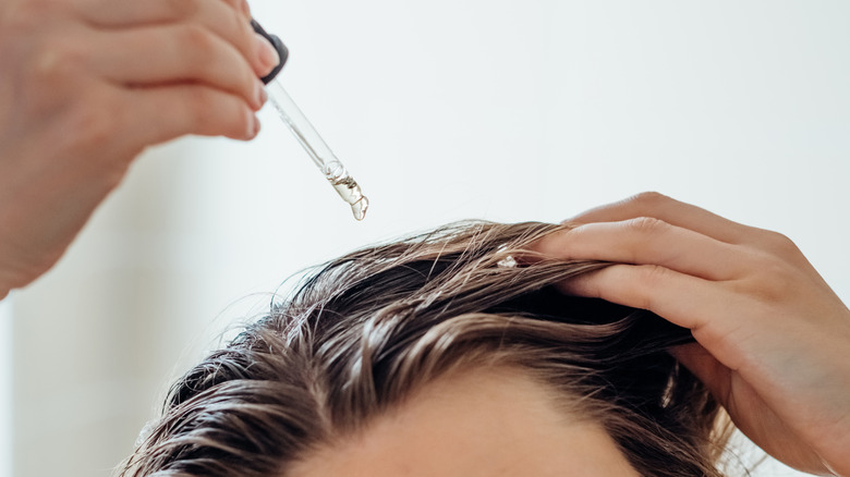 Man dripping oil in his hair