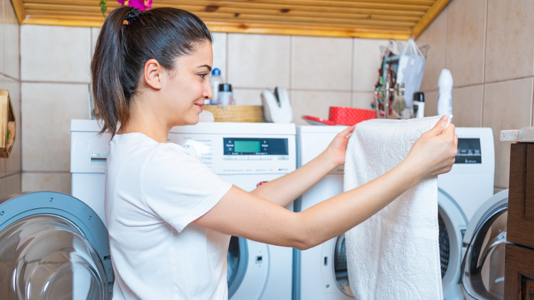 A smiling woman holding up mold free towel