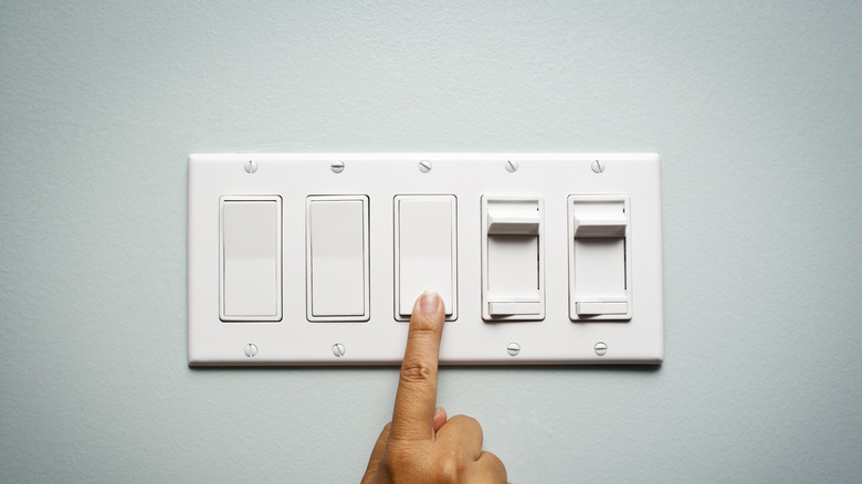 Person flicking rocker light switch