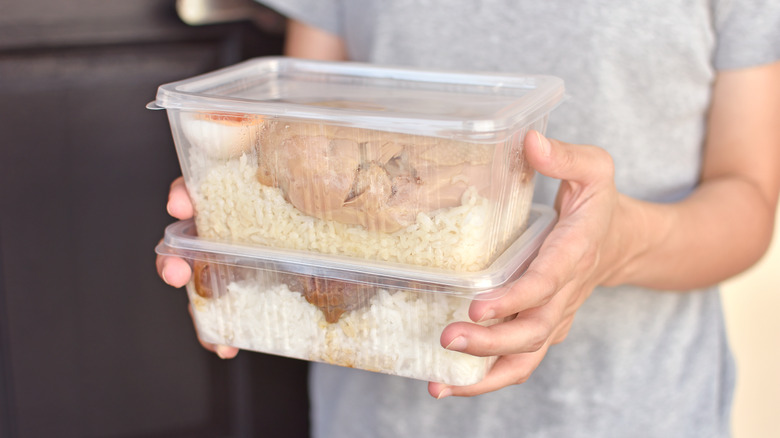 person holding plastic storage containers