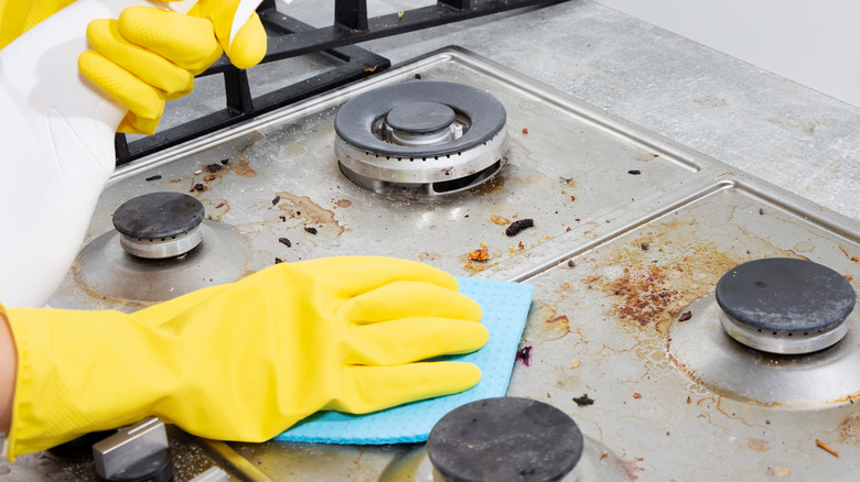 woman cleaning dirty stove