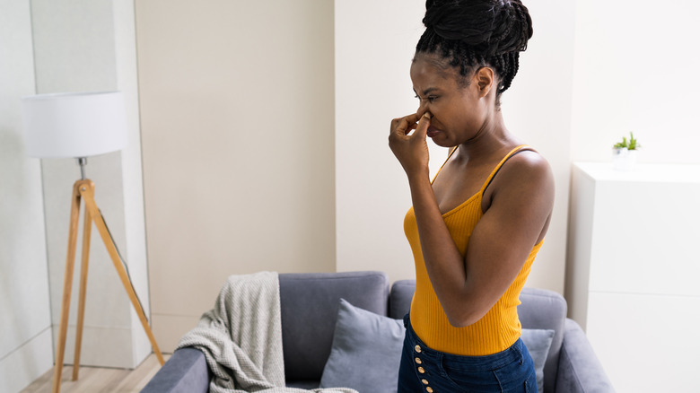 woman holding nose