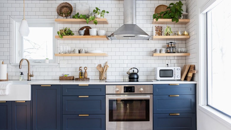 Bright kitchen with blue lower cabinets and open shelving