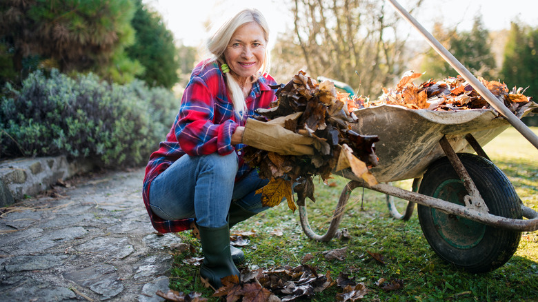 A woman cleans up a backyard