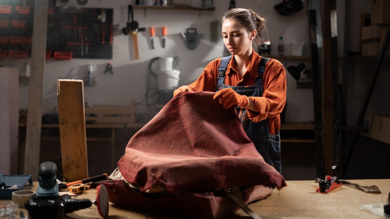 woman reupholstering arm chair fabric