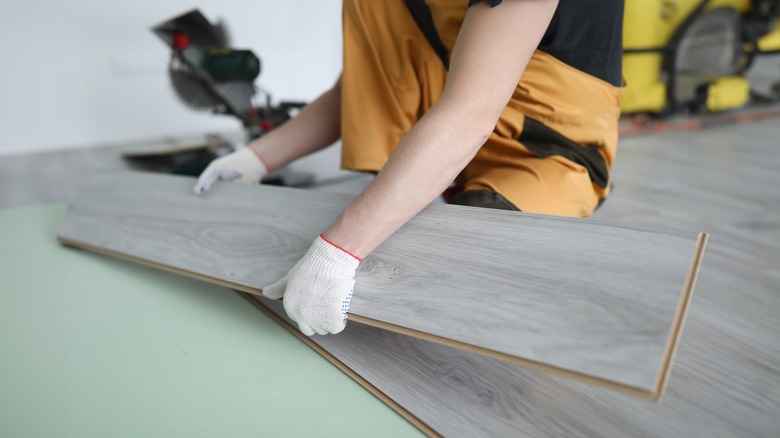 A person laying a laminate floor