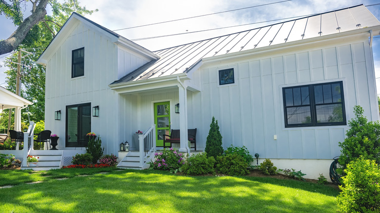 Modern white house with white vinyl siding in backyard