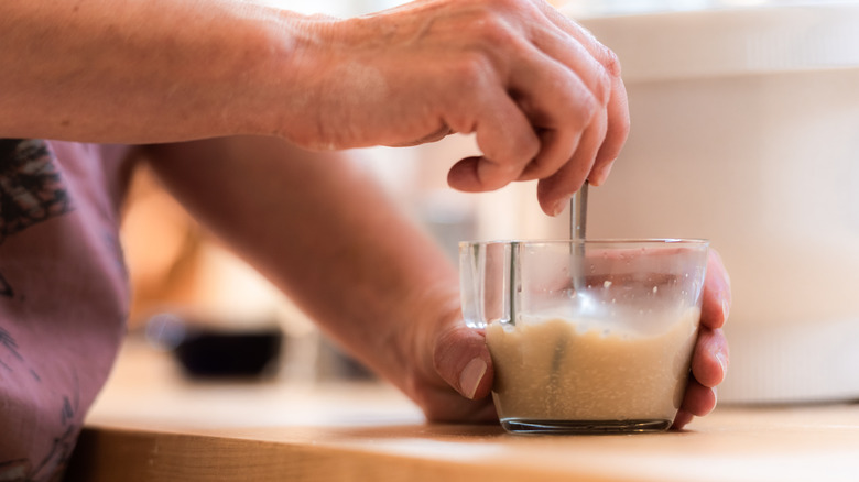 person mixing yeast and water