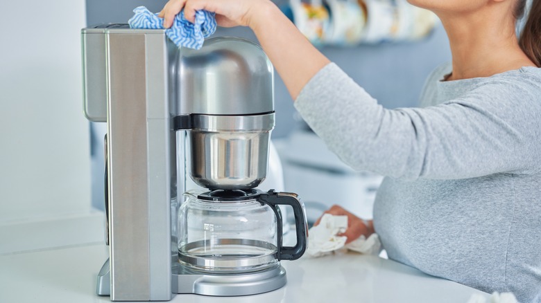 Woman cleaning coffee machine