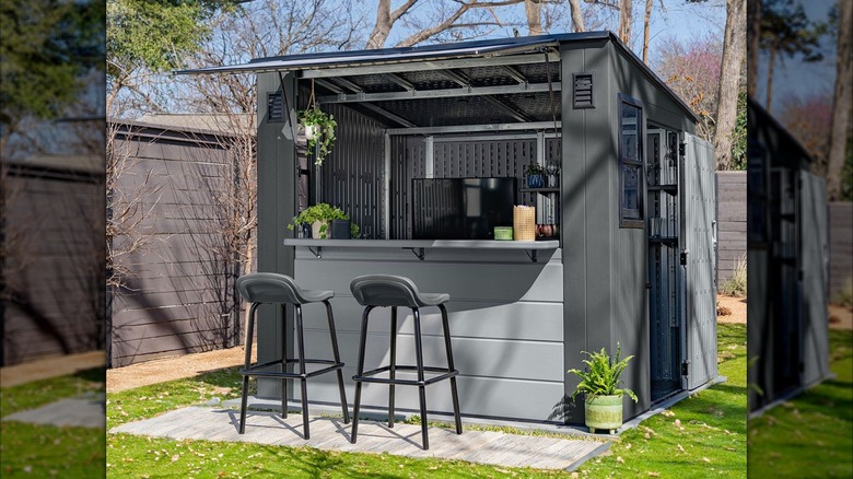 Two bar stools sit in front of the Suncast Cabana Entertainment Shed