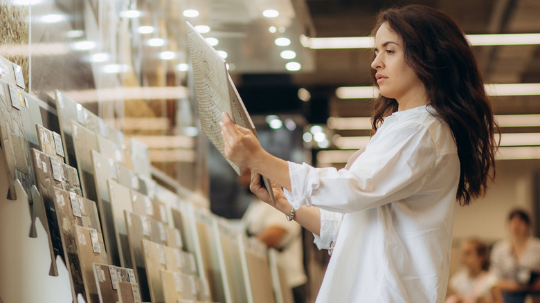 Woman looking at various bathroom floor tile samples