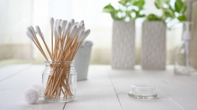 Cotton swabs in jar on table