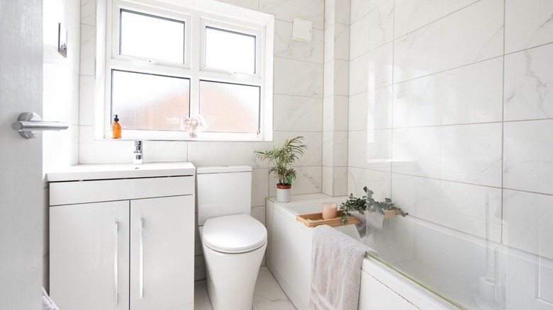 A small bathroom with clean white style with limited storage.