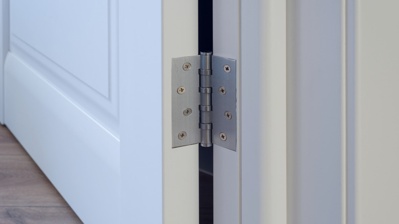 a close up of a door hinge on a white door