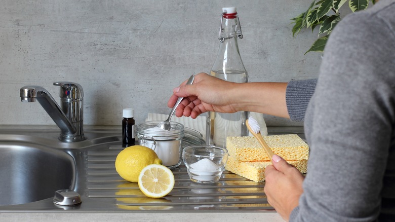 Woman cleaning with toothbrush and baking soda