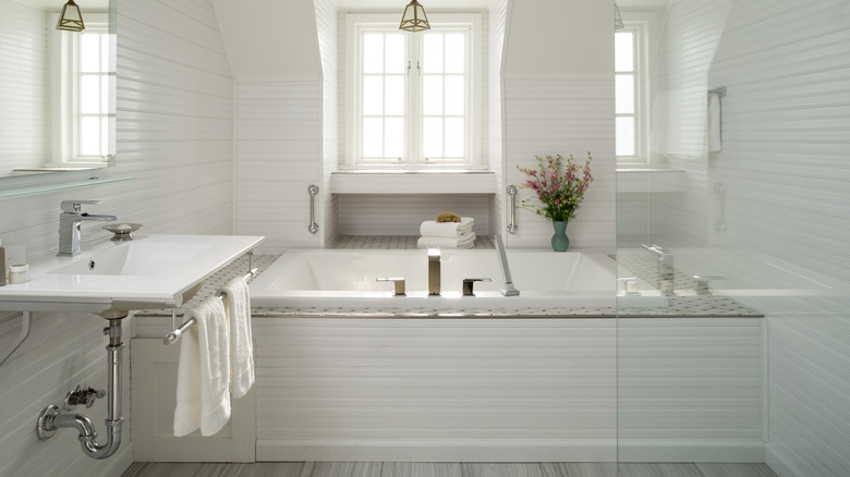 White bathroom with bathtub and white walls