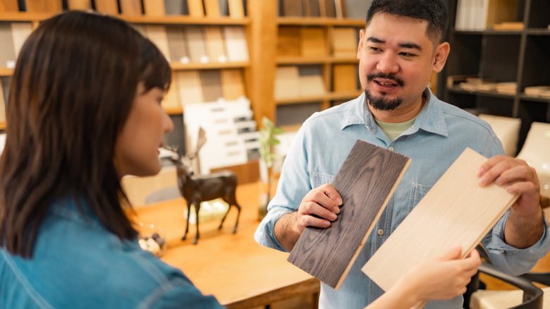 Woman comparing different wood panels with a sales associate in a department store