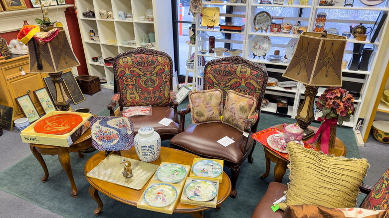 Thrift store with chairs, lamps, tableware, vases, and soft furnishings