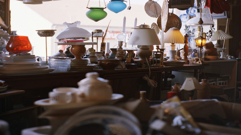 A collection of vintage ceiling lights and table lamps in a thrift store.