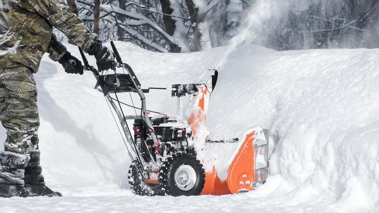 Person snowblowing large pile of snow