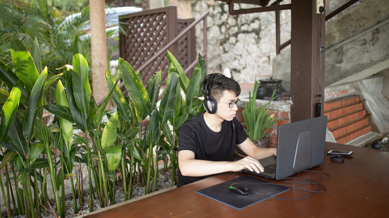 man using laptop in backyard