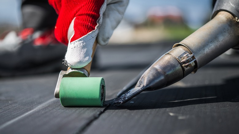 roof worker applying EPDM roofing