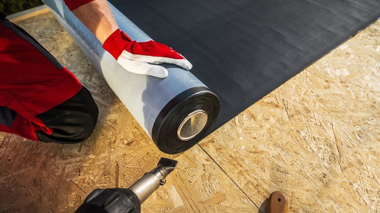 roof worker with EPDM roll